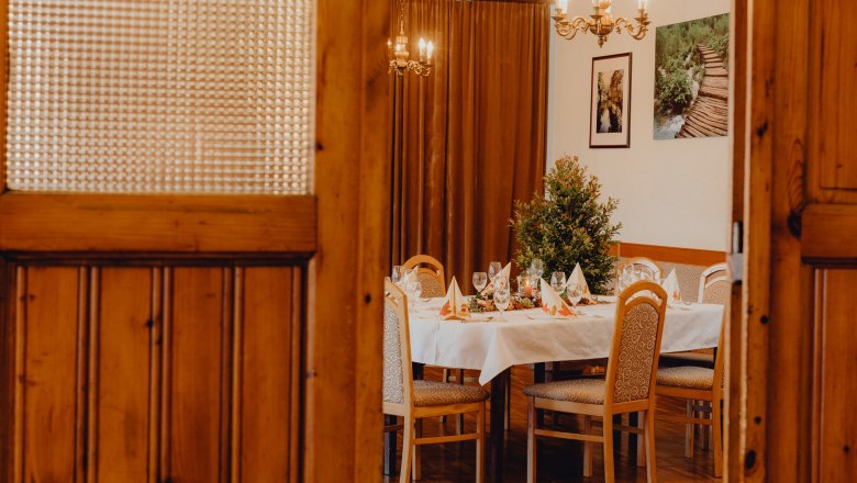 A festively laid table in a room with wooden doors and chandeliers.