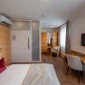 Modernly furnished hotel room with bed, desk, chair and TV.