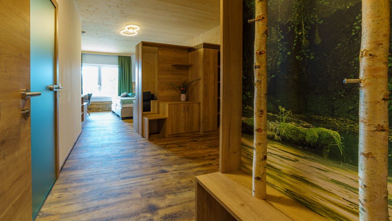 Interior view of a modern apartment with wooden floor, wooden furniture and a large window.