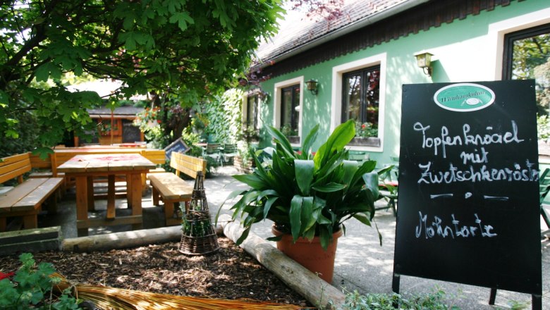Cozy guest garden with wooden benches and table at Wirtshaus Bonka, Wienerwald.