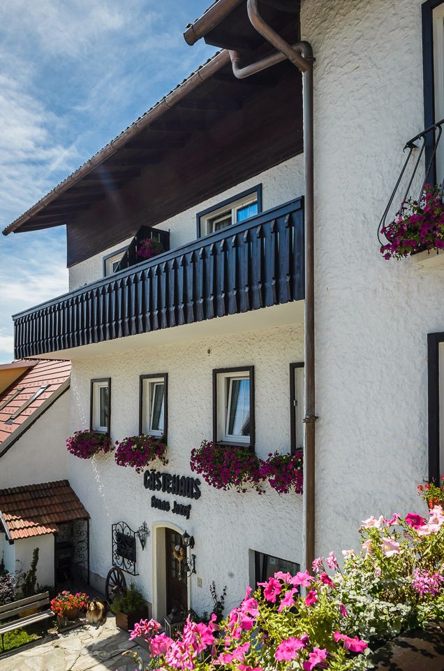 Traditional guest house with flower-decorated balcony and façade.