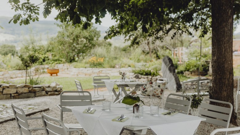 Garden with tables and chairs under a chestnut tree.