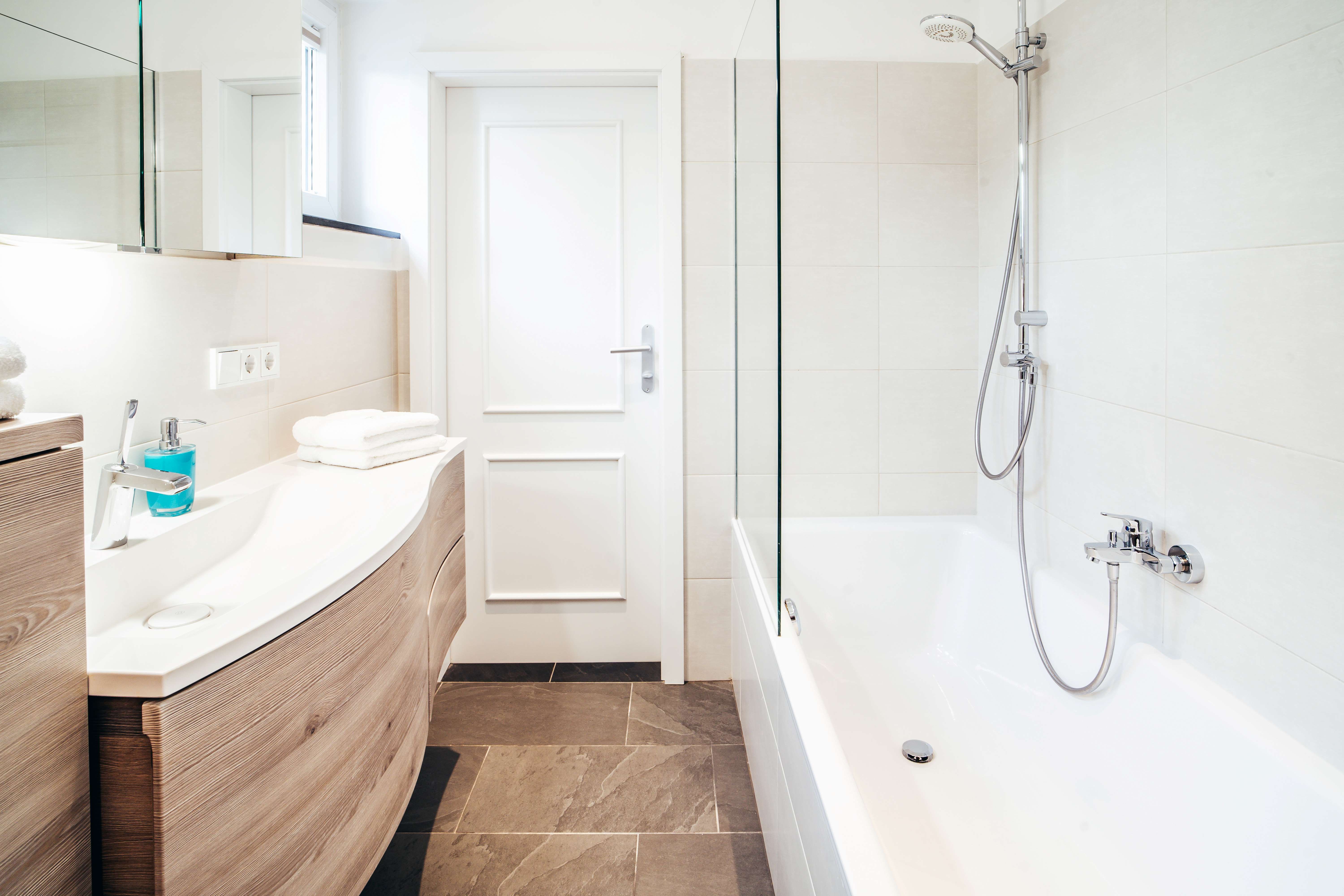 Modern bathroom with bathtub, washbasin and mirror.