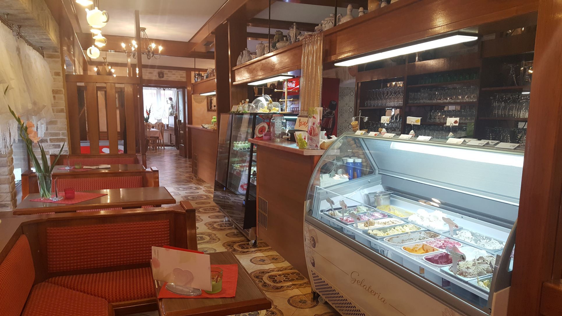 Interior view of a café with ice cream counter and seating areas.