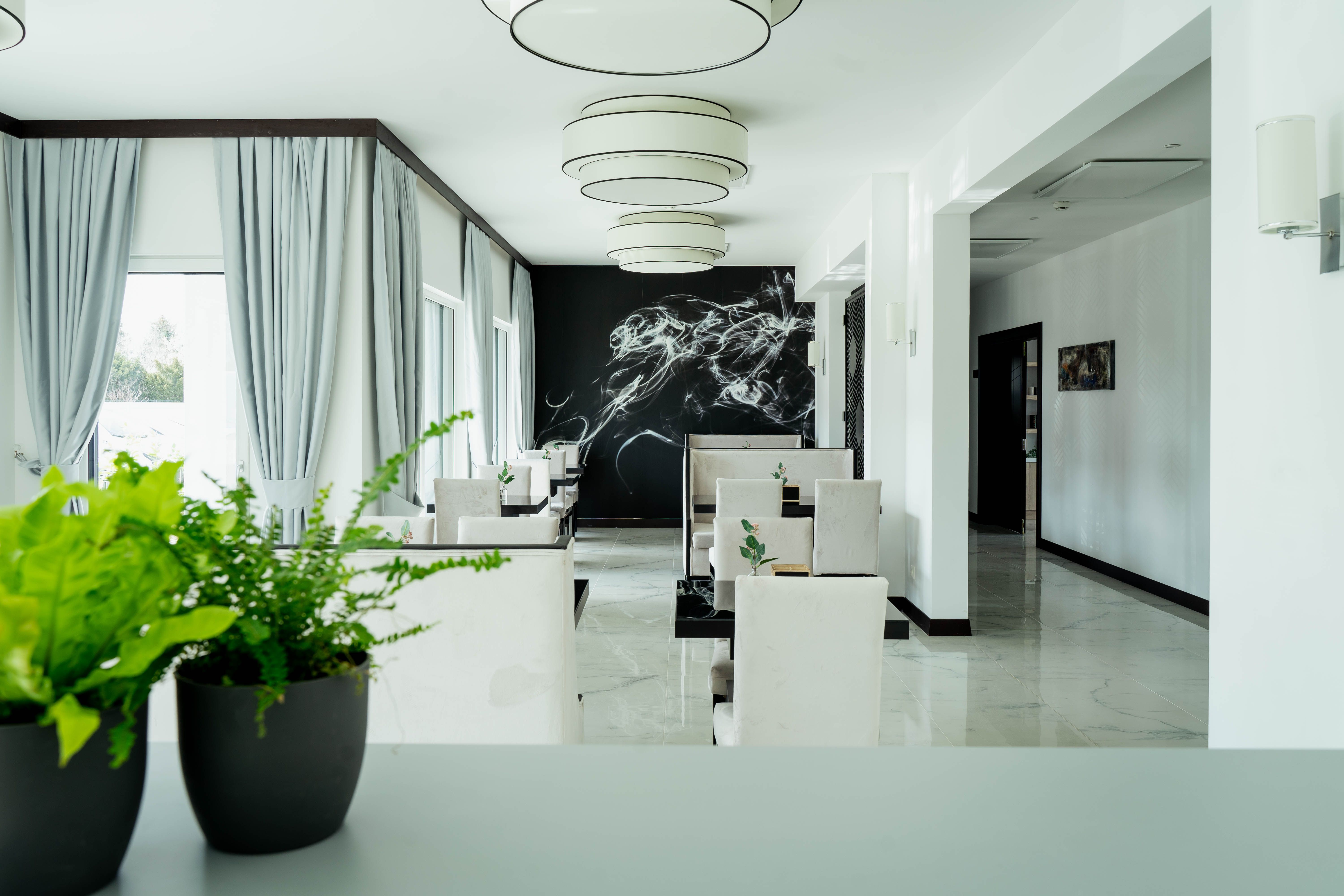 Elegant hotel lounge area with modern furniture and plants.