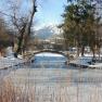 Snow-covered landscape with frozen river and bridge in Reichenau.