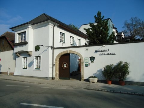 Entrance gate to the Kas-Nigl winery with white fa&ccedil;ade and plants.