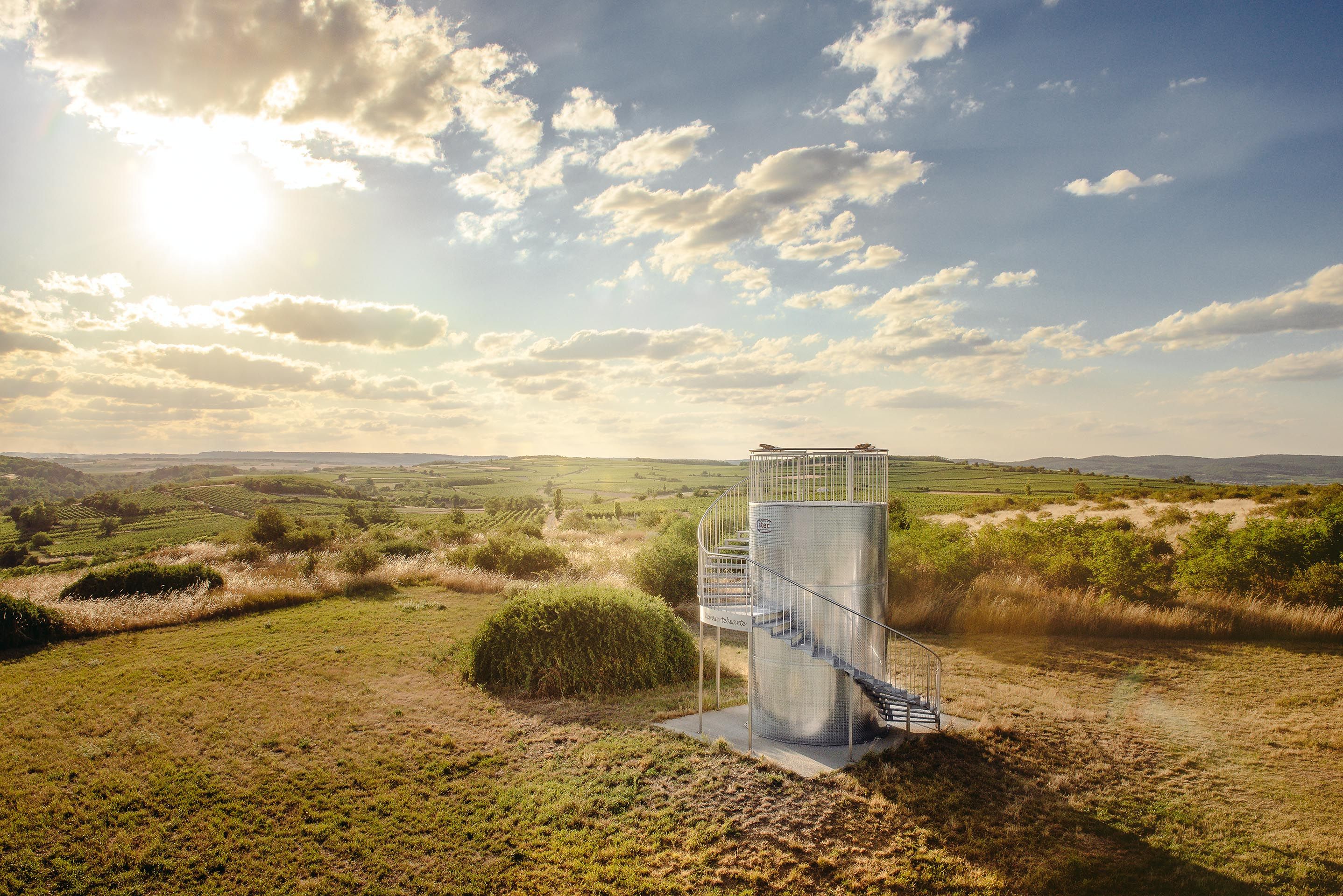 Observation tower in a rural landscape at sunset.