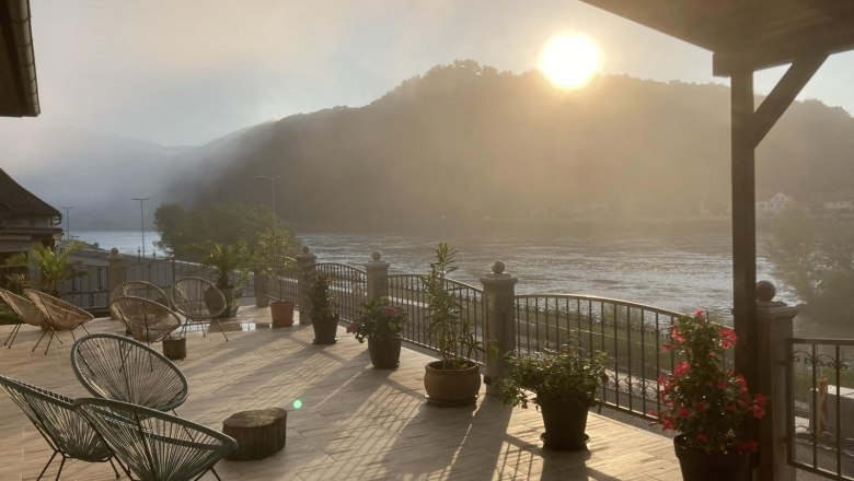 Terrace with a view of the river and mountains at sunrise.