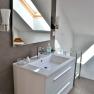Modern bathroom with washbasin, mirror and skylight.