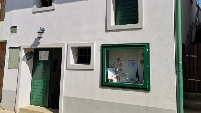 White house façade with green door and window frames. A sign with the inscription 'Bauers Kellerrast' is visible.