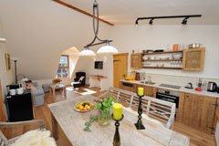 Cozy kitchen and dining area in a rustic style with wooden furniture and modern equipment.