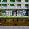 Modern building complex with green inner courtyard and water basin.