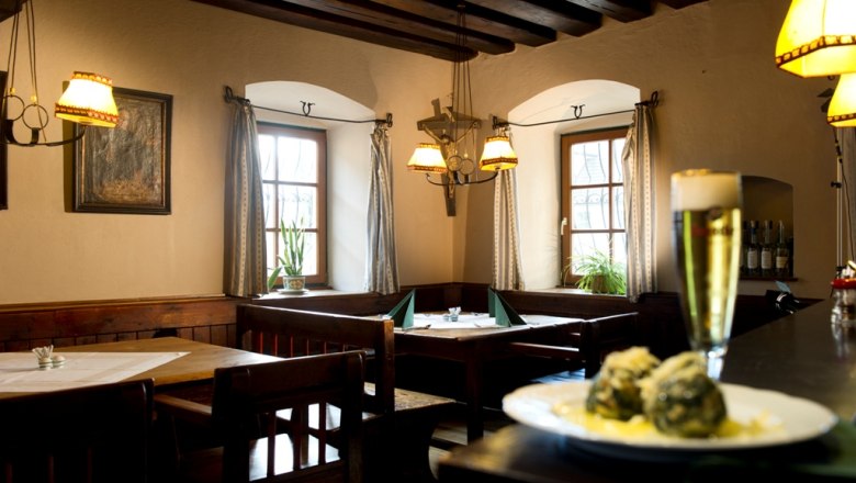 Cozy restaurant with wooden furniture, beer and dumplings on a table.