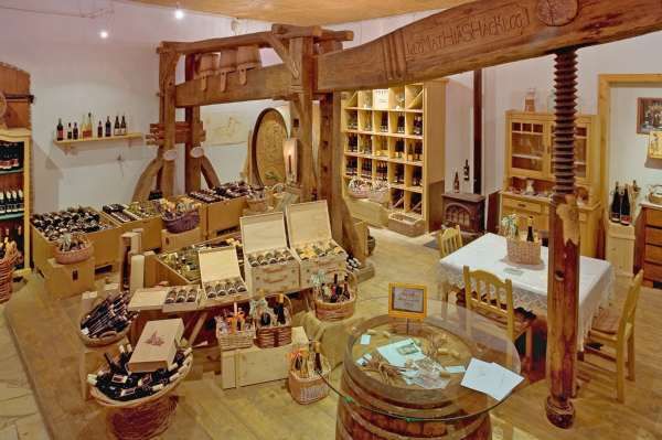 Interior view of a rustic farm store with wine bottles and wooden furniture.