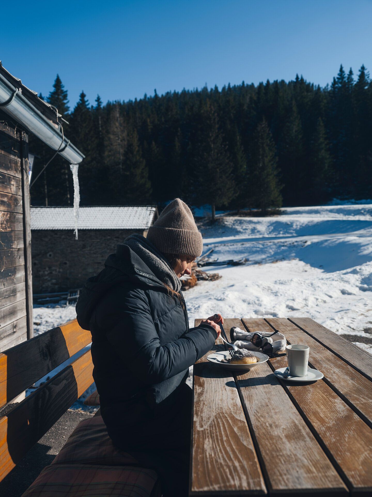 In der winterlichen Idylle der Wiener Alpen genießt man ein herzhaftes Frühstück im Freien. Die klare, kalte Luft und die schneebedeckte Landschaft schaffen eine perfekte Kulisse für einen entspannten Start in den Tag. Umgeben von majestätischen Tannen und der Stille der Natur, wird jeder Bissen zu einem Genuss.