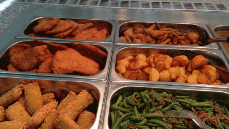 Buffet with breaded dishes, potatoes and green beans.