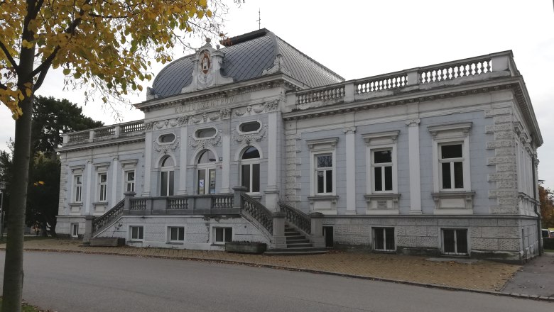 Exterior view of the Korneuburg City Museum in fall with yellow leaves in the foreground.
