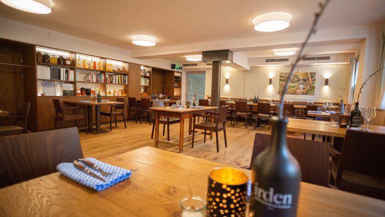 Interior view of a cozy restaurant with wooden furniture and decorative elements.