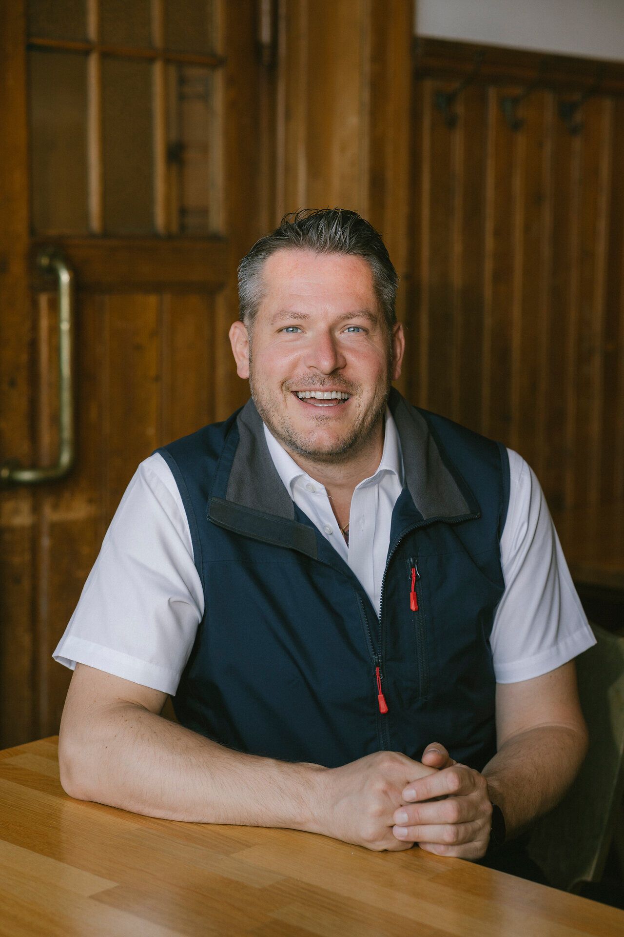 A smiling employee at a table at the Raxalm Mountain Inn