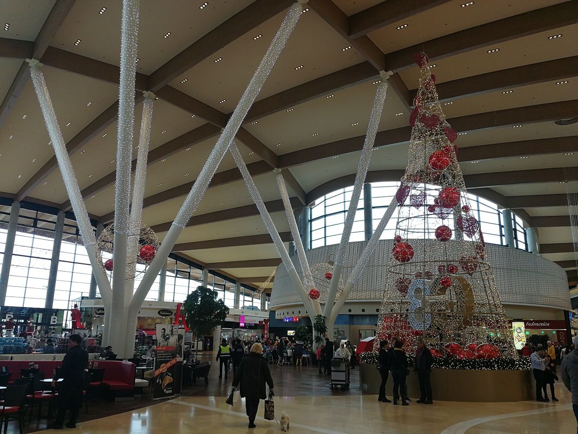 Interior view of a shopping center with Christmas decorations.
