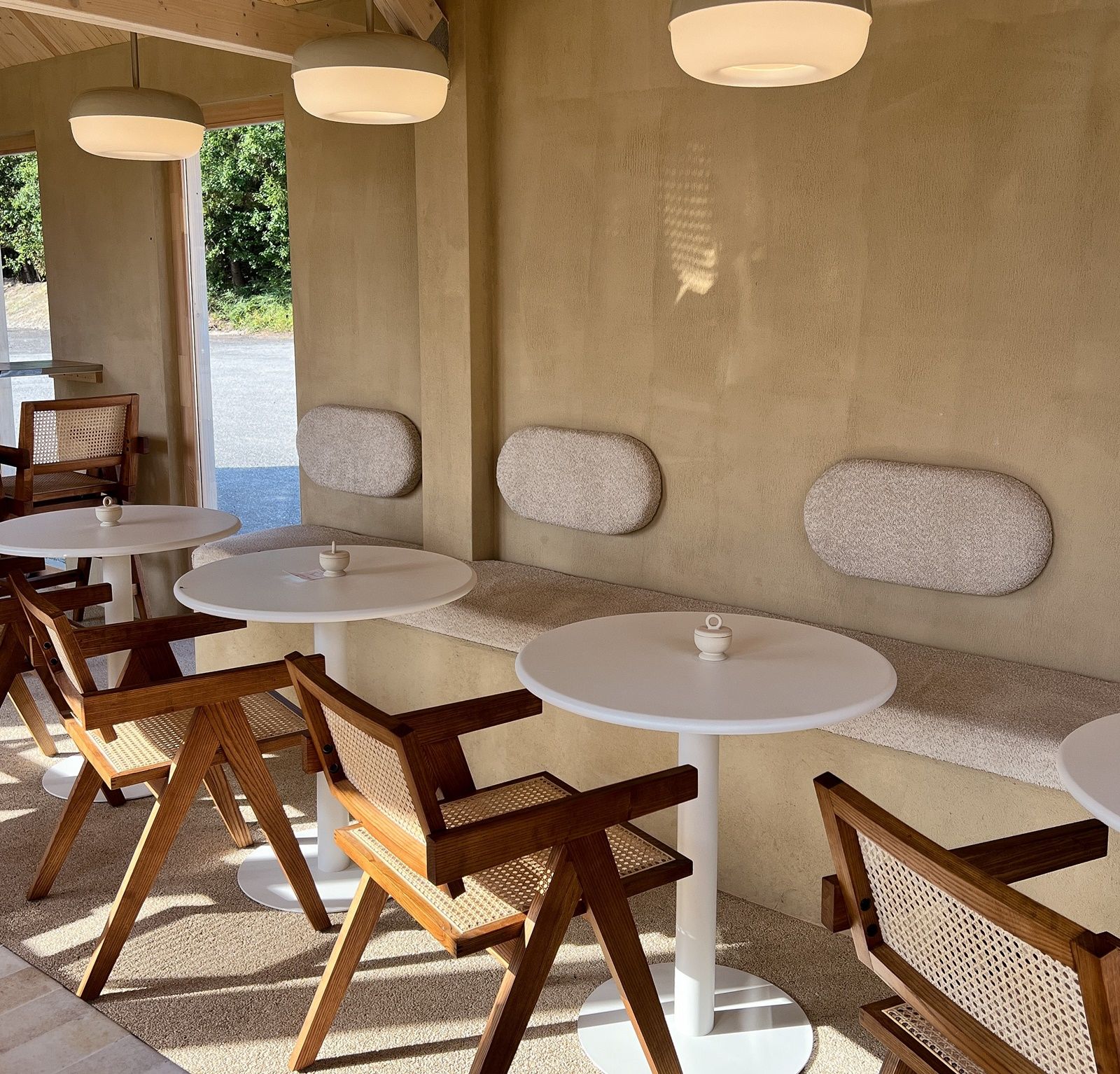 Interior of a café with wooden furniture and round tables.