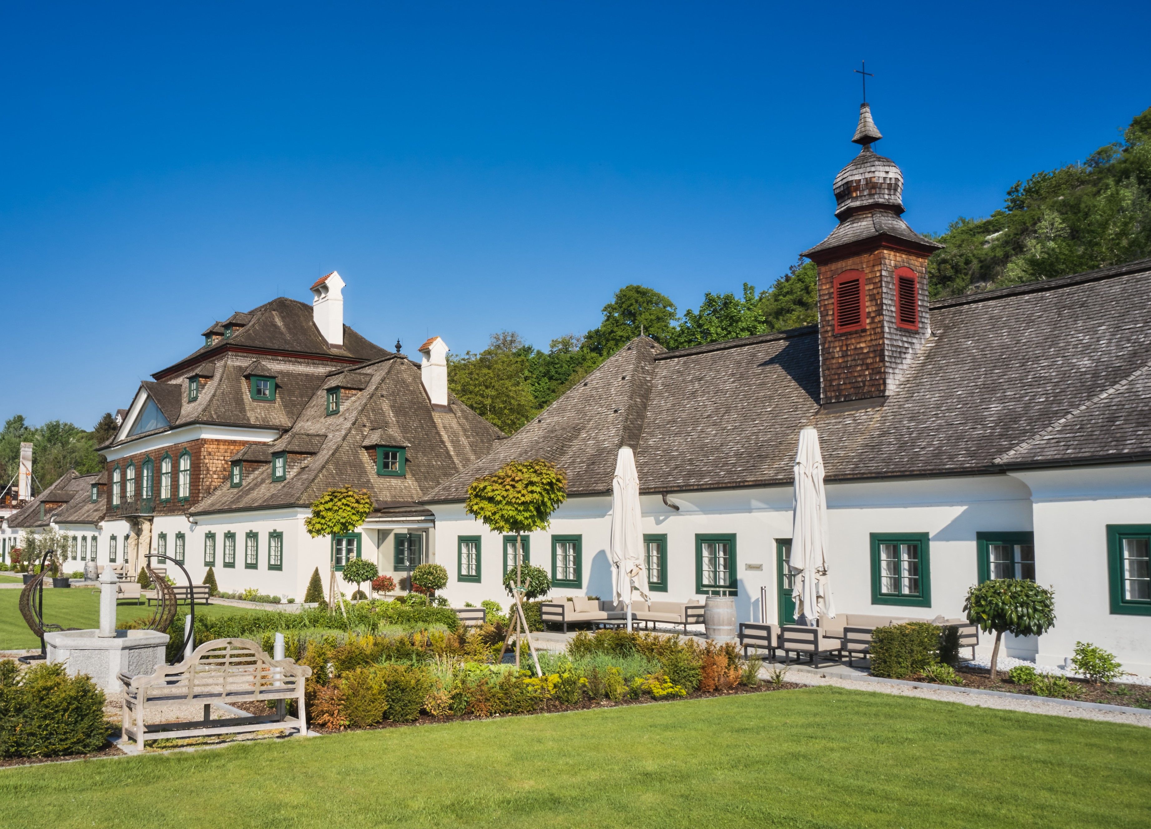 Schloss Luberegg with its well-tended garden and blue sky.