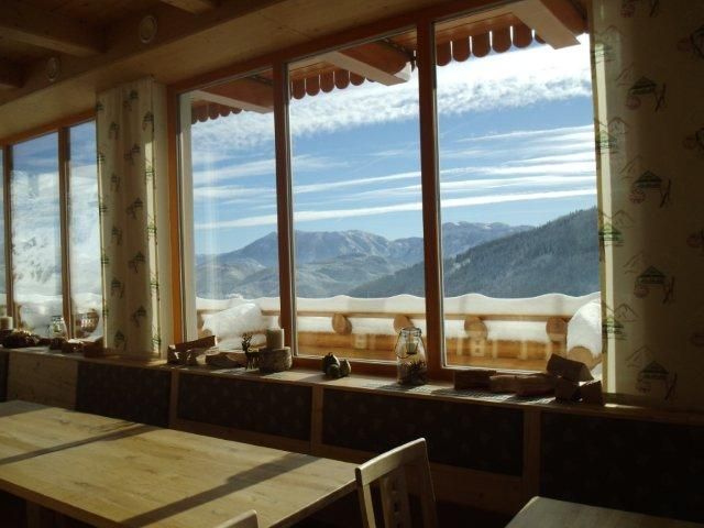 View from a window of snow-covered mountains and blue sky.
