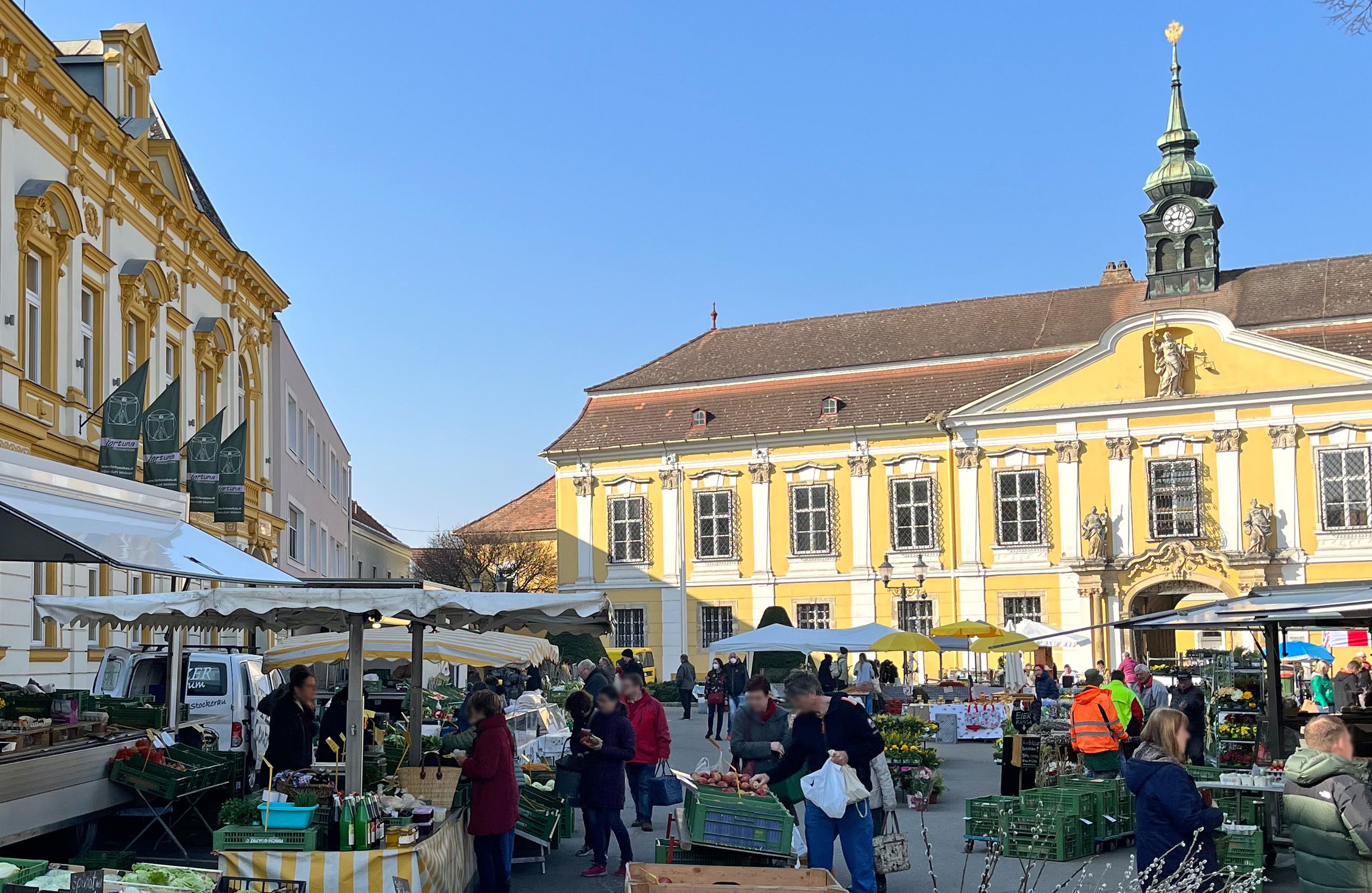 Weekly market in Stockerau with historic buildings in the background.