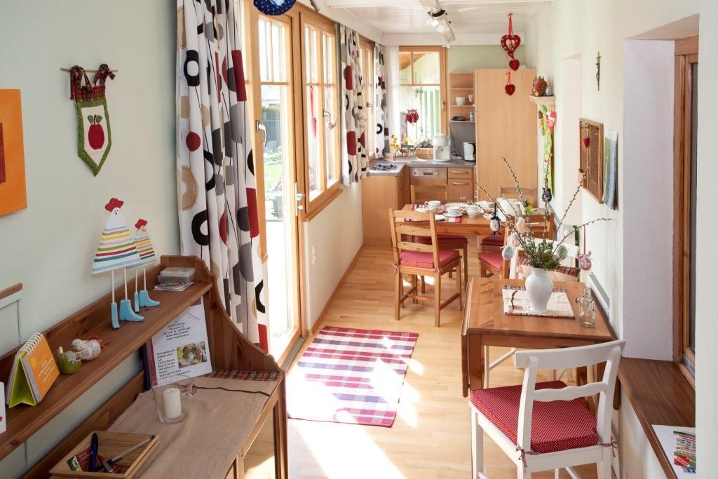 Cozy vacation apartment with wooden furniture, dining table and decorative curtains.