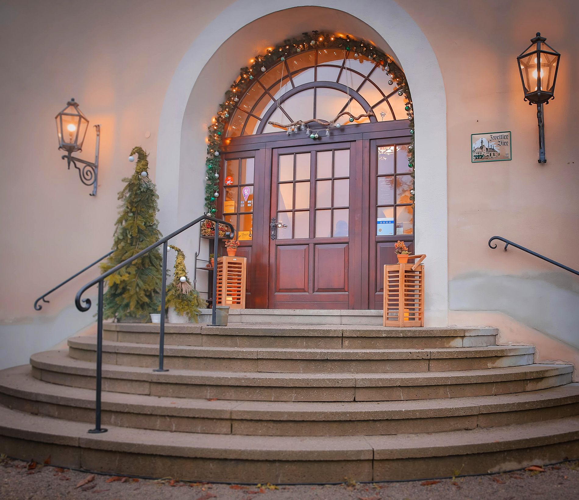 Entrance with decorated Christmas trees and lights.