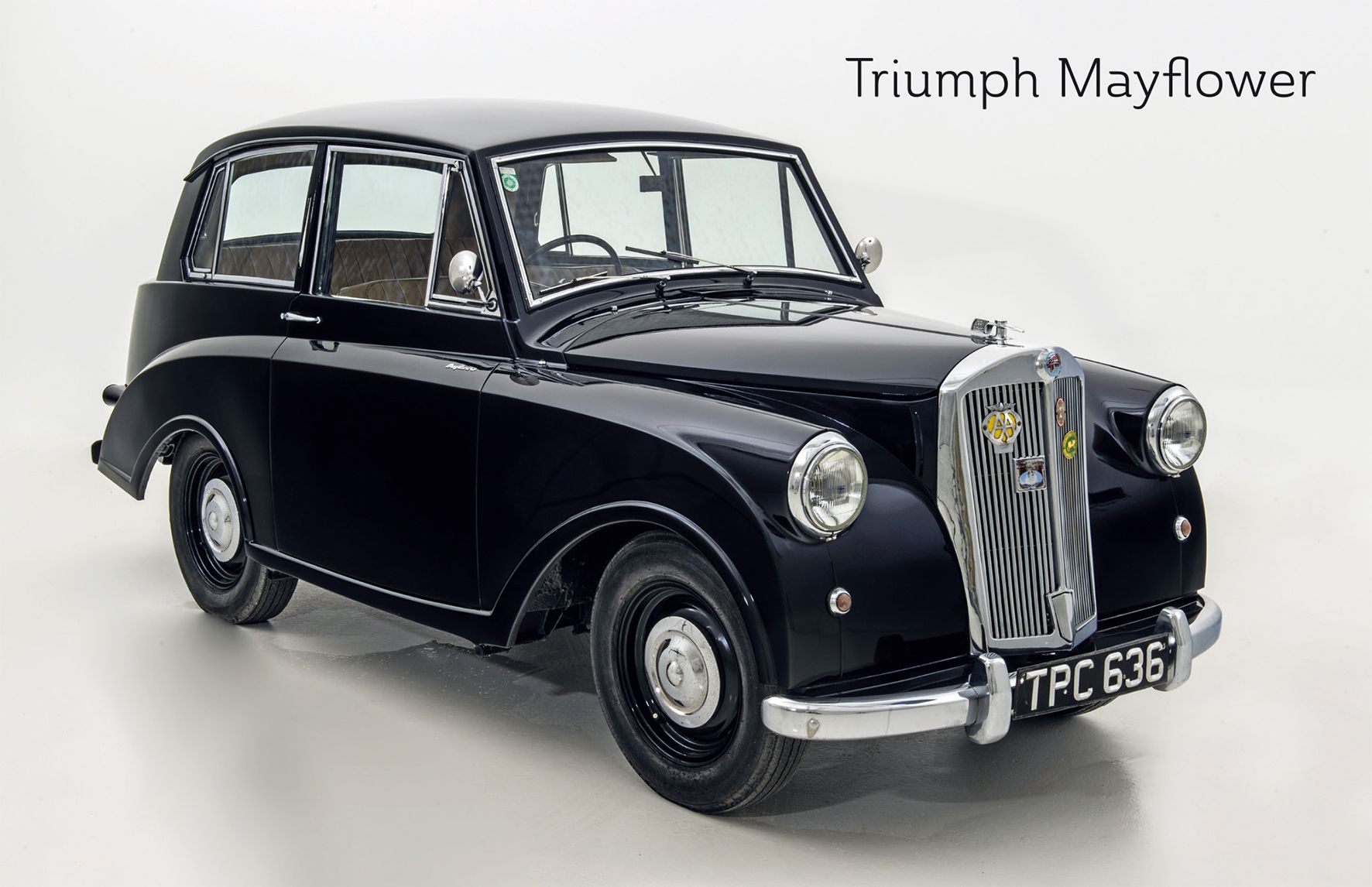 A black Triumph Mayflower vintage car against a white background.