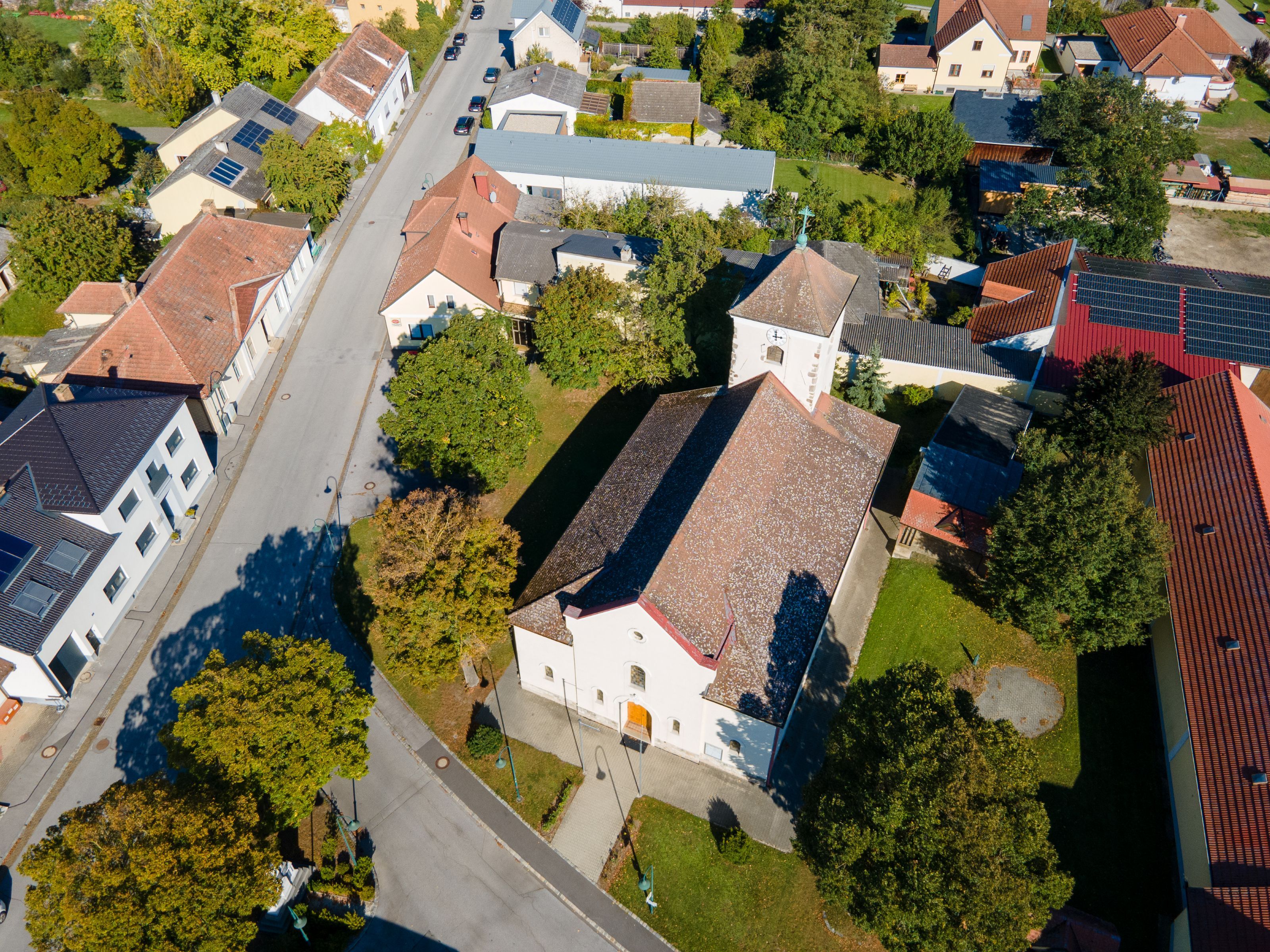 Aerial view of the town of Weiden an der March, showing the church, residential buildings, streets, and plenty of green space.