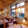 Cozy restaurant with wooden furnishings and large windows overlooking the countryside.