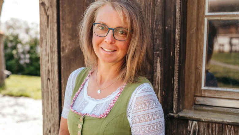 Sonja Langthaler in traditional dress in front of a wooden wall.