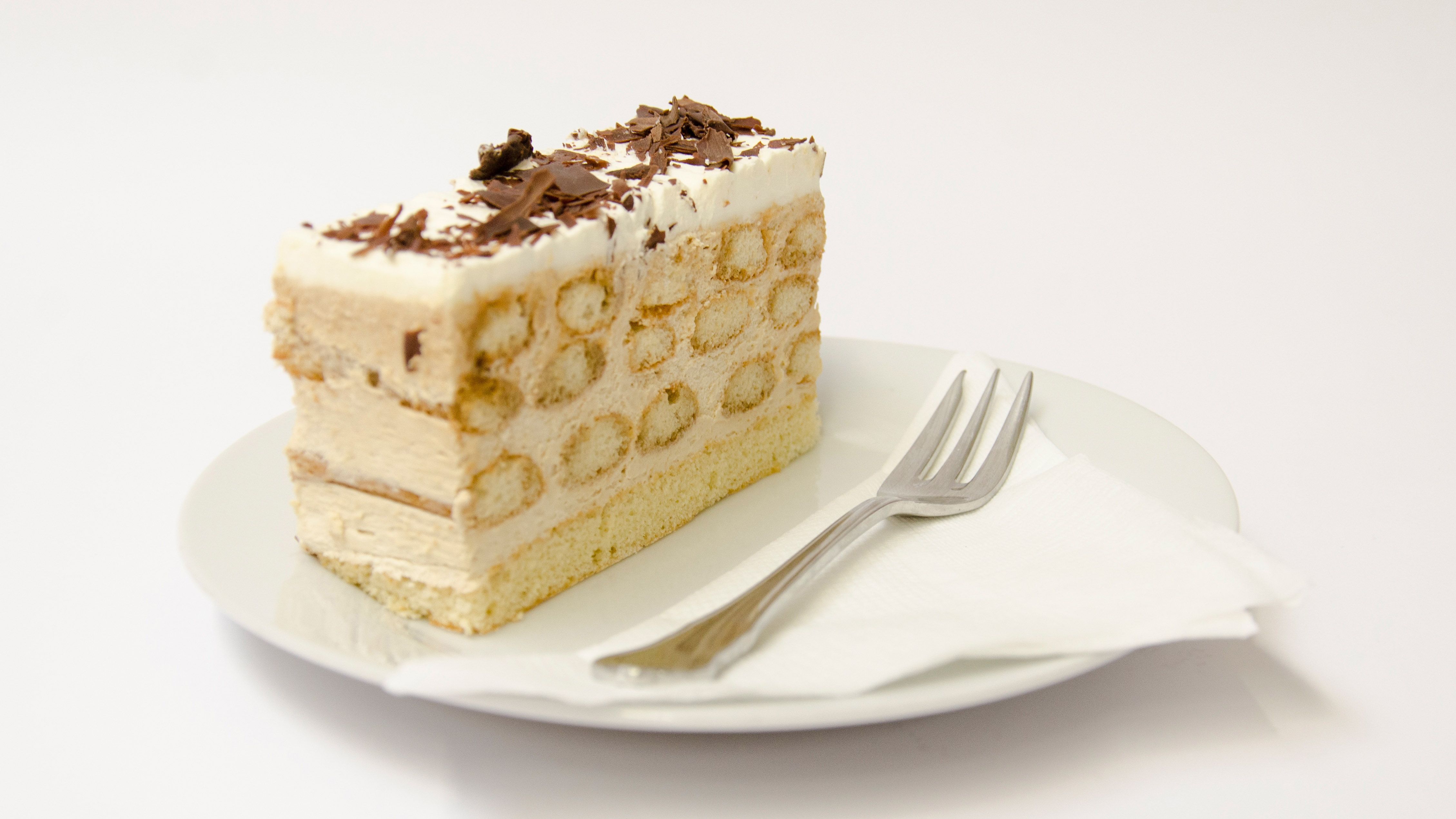 A piece of Malakoff cake on a plate with a fork.