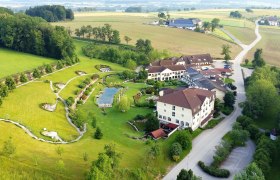 Aerial view of a resort with garden and pond in a rural setting.