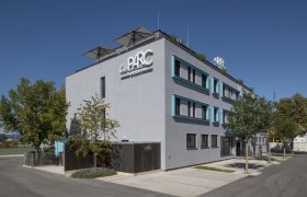 Modern building with the inscription 'Le Parc' and trees in the foreground.
