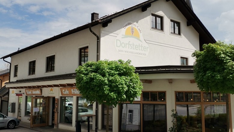 Exterior view of the Dorfstetter bakery with trees in front.