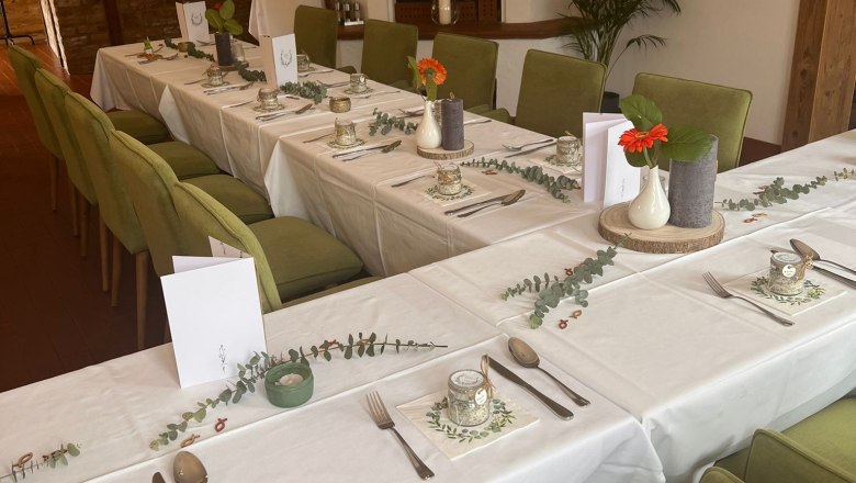 Elegant restaurant with laid table, green chairs and fireplace.