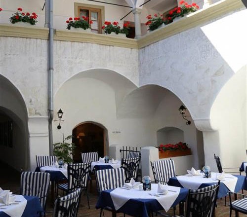 Inner courtyard of an inn with laid tables and flowers.