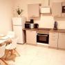 Modern kitchen with dining table, fridge, stove and microwave.