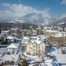 Snow-covered city with mountains in the background.