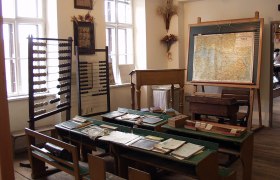 Historical classroom with abacus, map and old school desks.