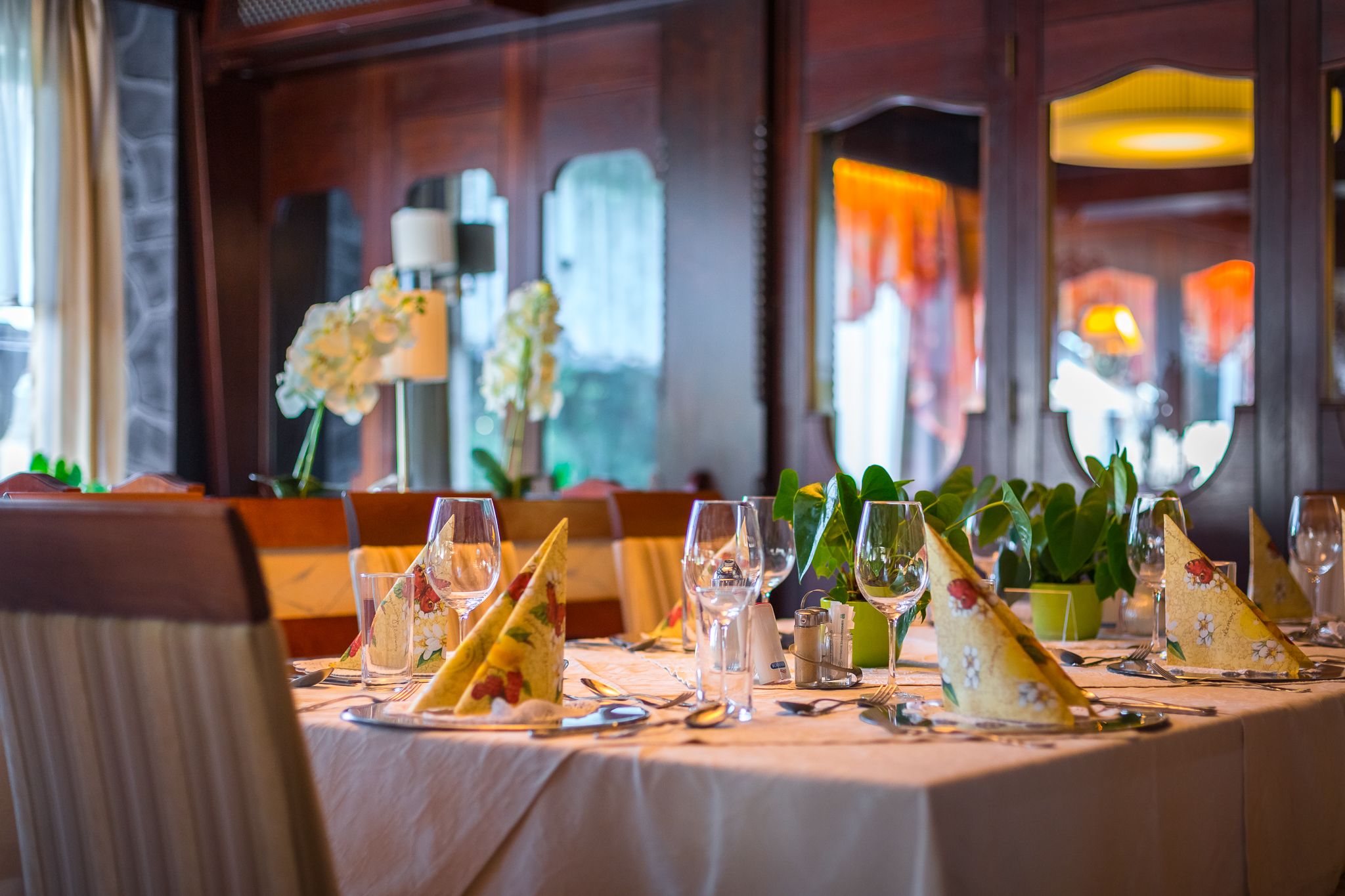 Dining room tables laid out with napkins and wine glasses. 