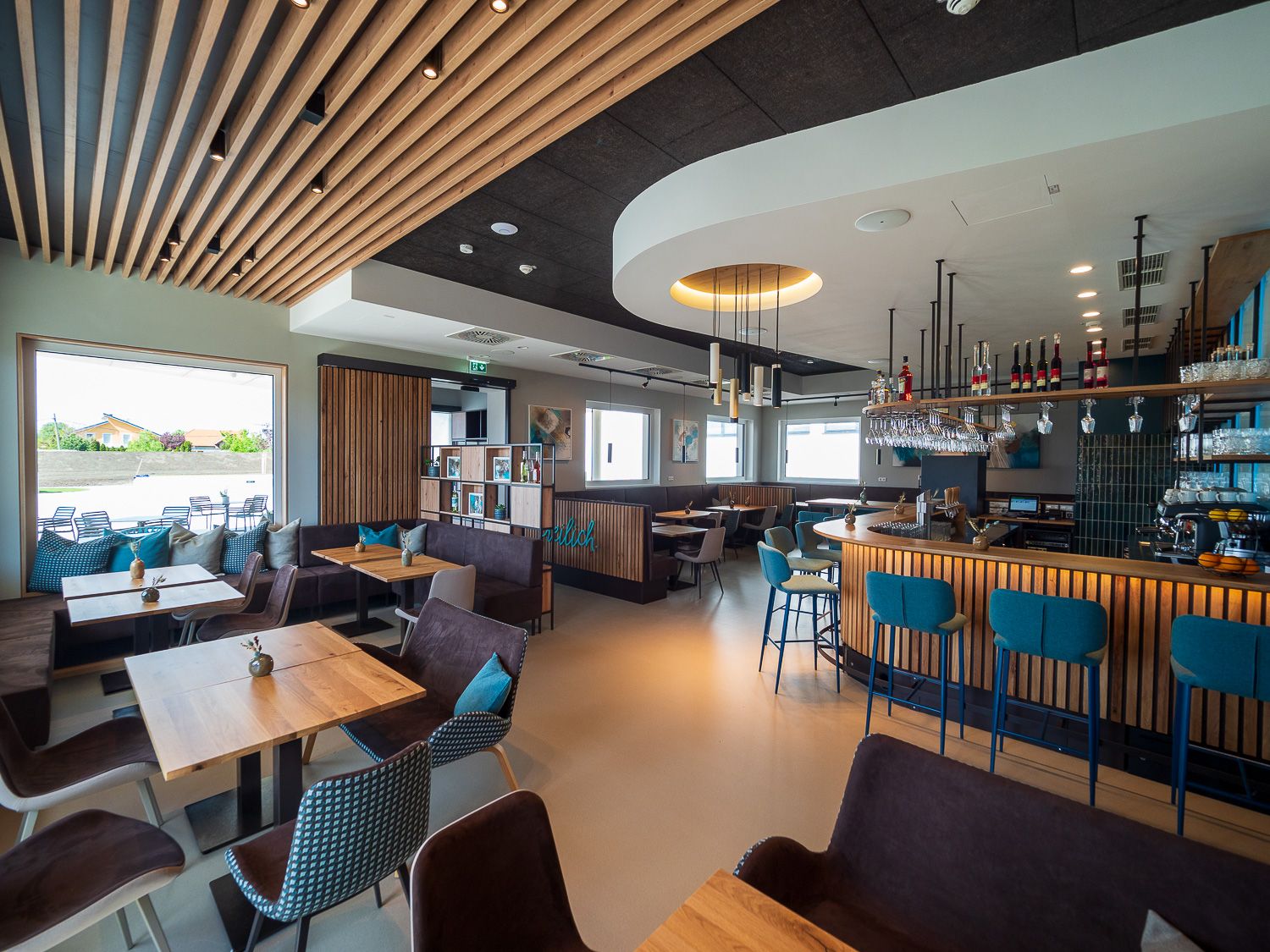 Modern bistro with wooden furniture, bar and large windows.