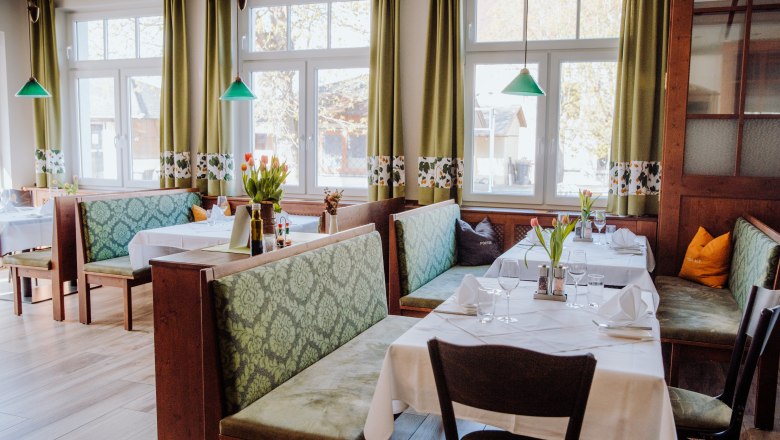 Cozy restaurant with green benches and table decorations.