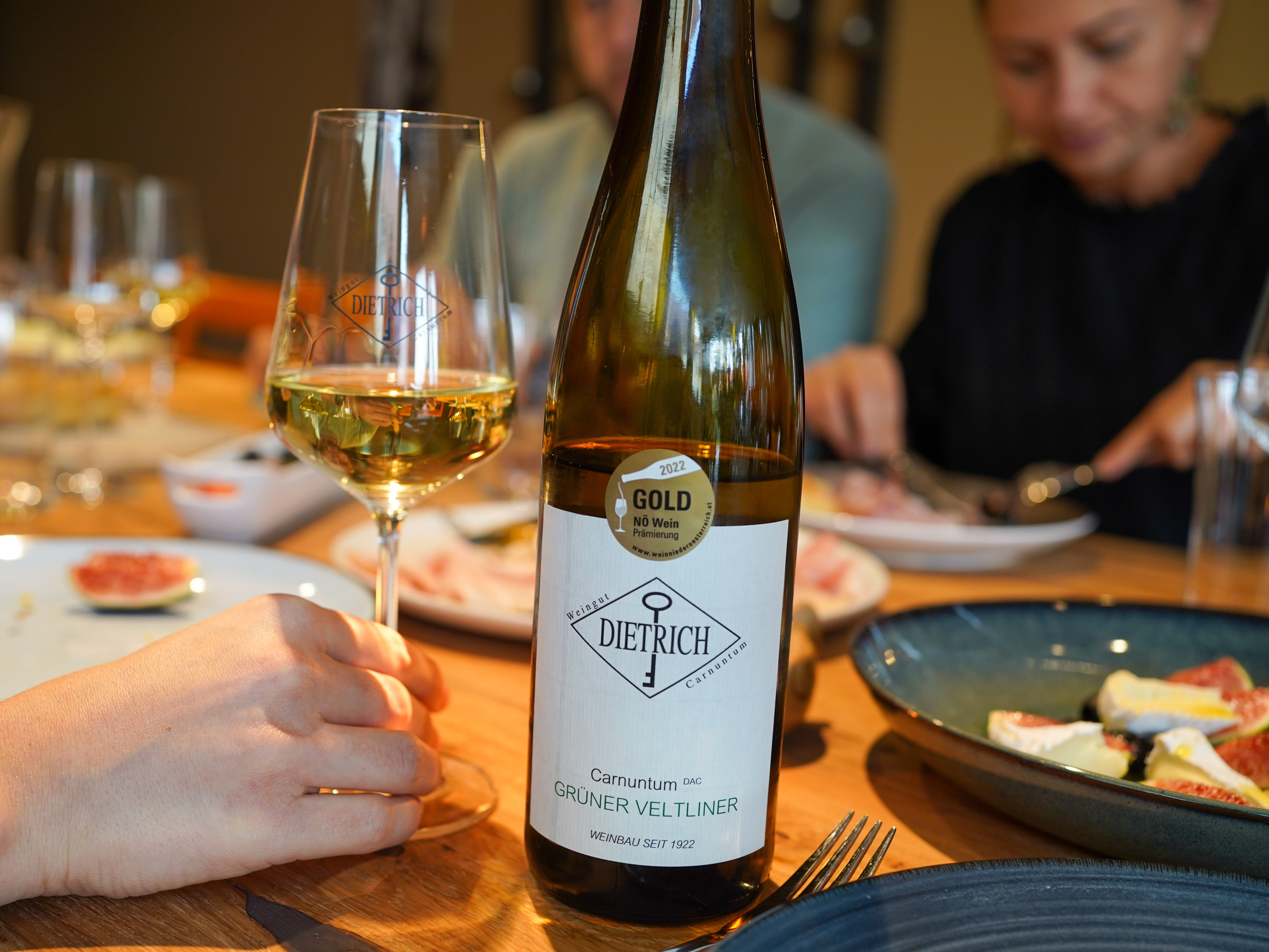 Wine bottle and wine glass at a laid table with food