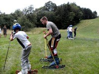People skiing on grass in a meadow.