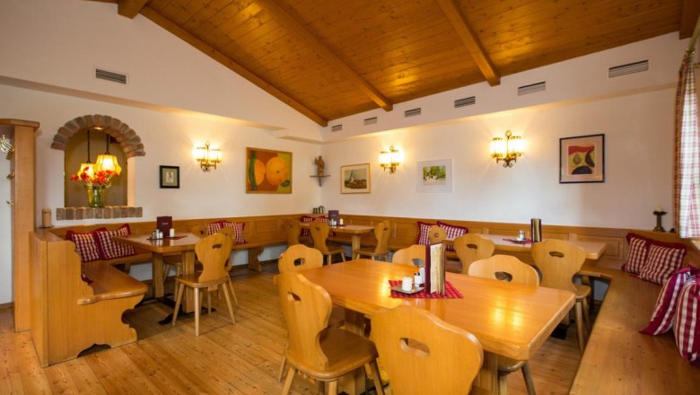 Cozy living room with wooden furniture, checkered cushions and wall decorations.